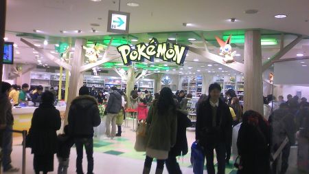 Una fotografía coloreada muestra a personas paradas frente a un Centro Pokémon en Sendai, Japón.
