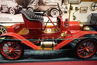 Fotografía en color de un Maxwell Roadster rojo de 1910, un automóvil con un solo asiento.