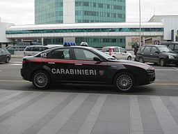 Imagen en color de un Alfa Romeo negro con letras prominentes que dicen Carabinieri en el costado del vehículo en blanco.