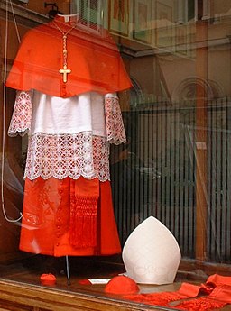 Foto de la túnica escarlata y blanca de un cardenal de la Iglesia católica exhibida en un maniquí.