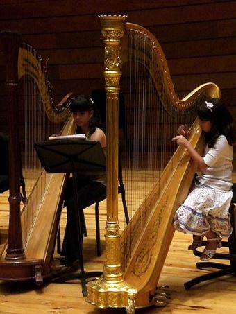 dos chicas tocando el arpa