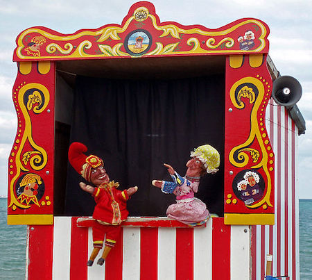 Fotografía en color de los títeres Punch y Judy dentro de un pequeño escenario portátil para títeres.