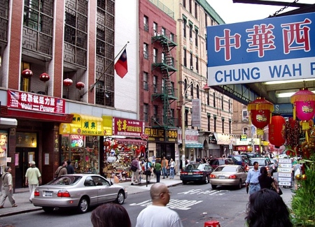 Imagen de una calle de China Town, con un edificio más grande a lo largo de la calle.