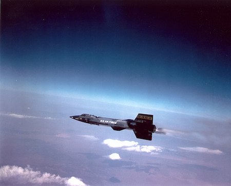 Una fotografía de un avión militar estadounidense con el logotipo de la NASA en el horizonte con el espacio encima y la Tierra debajo.