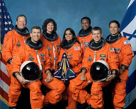 Una fotografía de los siete miembros de la tripulación de la STS-107 con trajes espaciales.