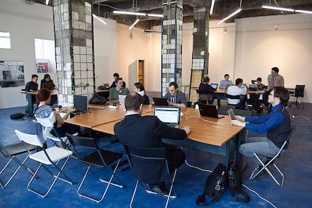 Una imagen de personas trabajando en un espacio de oficina compartido.
