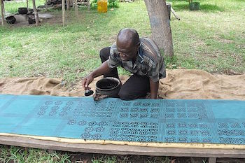 Hombre imprimiendo tela Adinkra