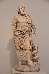 Una estatua de mármol de un hombre con una túnica con una serpiente alrededor de su bastón.