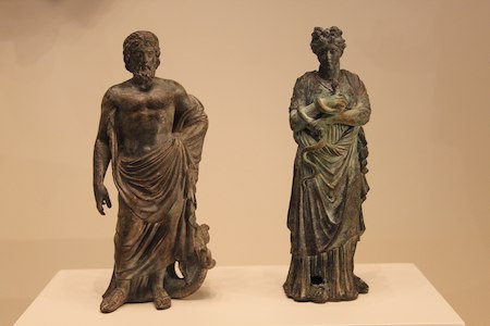 Fotografía de dos pequeñas estatuas de bronce, una de Asclepio y otra de Higía.