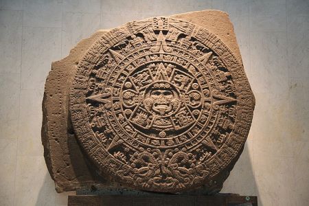 Fotografía de una enorme piedra tallada, la piedra del calendario azteca, que representa símbolos del calendario azteca.