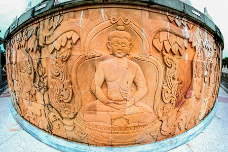 Imagen de Buda sentado rodeado de elaborada ornamentación.
