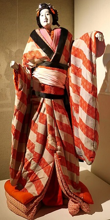 Imagen en color de una marioneta Bunraku femenina en una vitrina de cristal