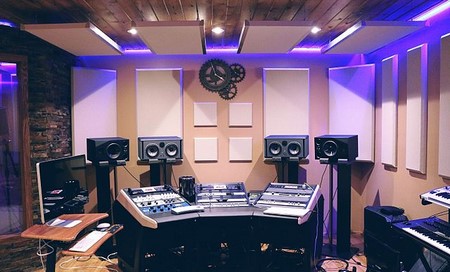 Una sala con parlantes y pupitres de música que tienen muchos botones y nobs.