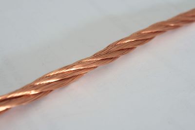 Esta imagen muestra varios cables de cobre entretejidos sobre un fondo blanco.