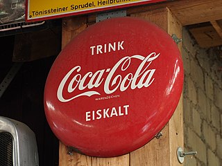 Un cartel de Coca Cola alemana, una tapa de cola roja con palabras en alemán colgando de una puerta
