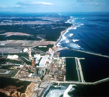 Vista aérea de una gran central eléctrica en construcción a lo largo de la costa del océano.
