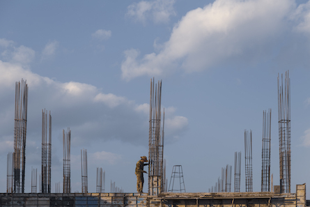 Foto de un trabajador de la construcción y un marco de metal.