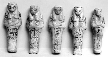 Fotografía en blanco y negro de cinco figuras ushabti de distintos tamaños.