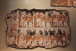 Imagen de un grupo de figuras danzantes con trajes repuestos agrupadas en un fragmento de pared de una tumba.