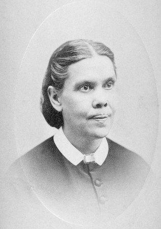 Una fotografía de Ellen Harmon White, una mujer que llevaba un vestido negro con botones y cuello blanco.