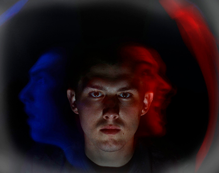 Fotografía de un hombre con caras multicolores mostrando emociones.