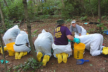 Imagen del Equipo de Respuesta a Evidencia del FBI recolectando evidencia en el bosque.