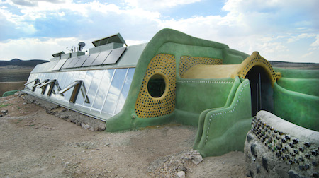 Estructura redondeada verde y metálica en el desierto.
