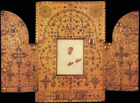 Un tríptico dorado con tres secciones y una imagen de una persona vestida de blanco en el medio.
