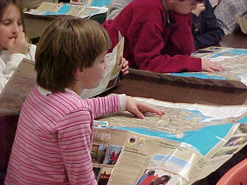 Una niña revisando una guía de viaje y un mapa.