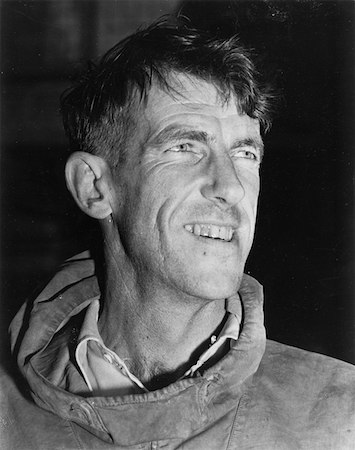 Una fotografía en blanco y negro de Sir Edmund Hillary cuando era joven y vestía equipo de montañismo.