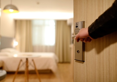 Puerta que se abre a la habitación del hotel con cama y asientos.