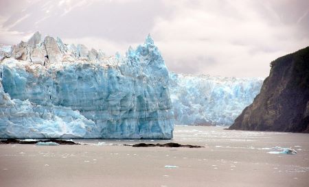 Una fotografía en color muestra un gran trozo de hielo puntiagudo sobre un terreno llano y nevado.
