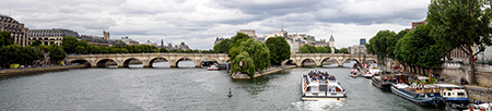 Una vista amplia del puente desde el río, con la Isla de la Cité que separa los dos segmentos arqueados.