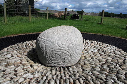 Una roca de piedra blanca y sólida con muchas tallas intrincadas y arremolinadas en su superficie.
