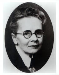 Una fotografía en blanco y negro de Julia Morgan con gafas y vestida profesionalmente.