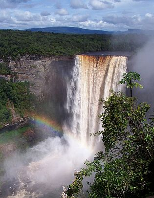 Fotografía de una cascada de gran caída con un arcoíris reflectante