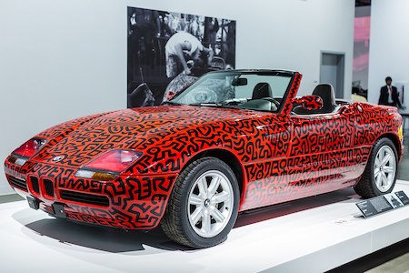 Fotografía en color del BMW convertible rojo en exhibición, pintado con patrones geométricos negros