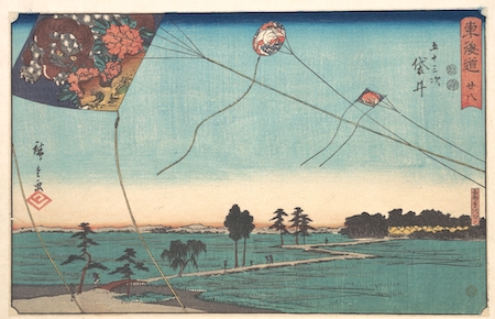 Representación en madera japonesa de cometas en vuelo sobre un paisaje
