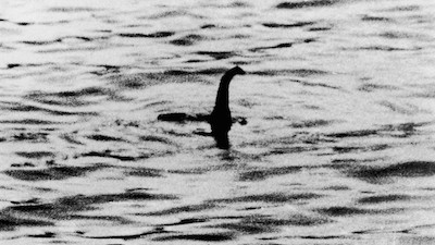 Fotografía en blanco y negro que supuestamente muestra al monstruo del lago Ness. La cabeza y la joroba del monstruo sobresalen del agua.