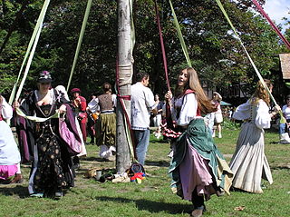 Fotografía en color de adultos haciendo la danza del árbol de mayo