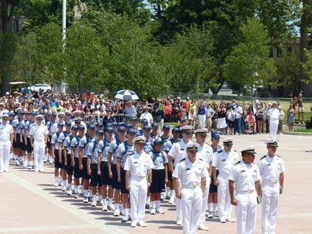 Guardiamarinas en formación mientras la multitud observa