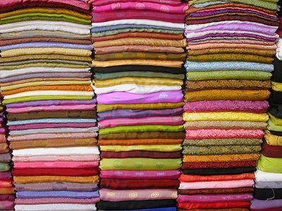 Una imagen de prendas que se venden en un mercado textil.