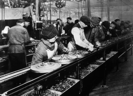 Una fotografía en blanco y negro de personas trabajando en una línea de montaje.