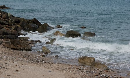 una imagen de olas rompiendo en rocas