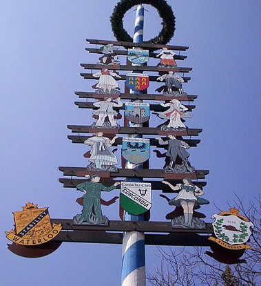 Fotografía de un árbol de mayo de Alemania con carteles en el poste