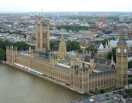 Una fotografía en color del Palacio de Westminster, un gran edificio gótico, y el río Támesis, tomada desde arriba.