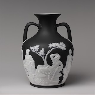 Una réplica en blanco y negro del jarrón Portland, con dos figuras sentadas y una de pie.