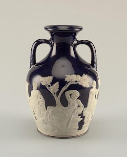 Un jarrón de color azul oscuro con dos asas pequeñas, con grabados en blanco de humanos, dioses y serpientes.