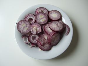Imagen de aros de cebolla roja cruda en un bol