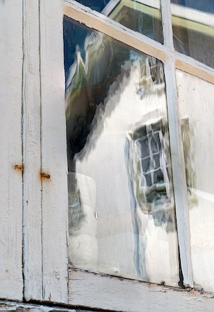 el reflejo en una ventana deformada, mostrando la superficie irregular del vidrio soplado a mano